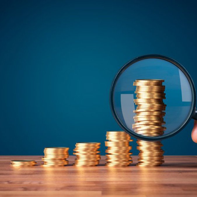 Stacks of coins examined with magnifying glass